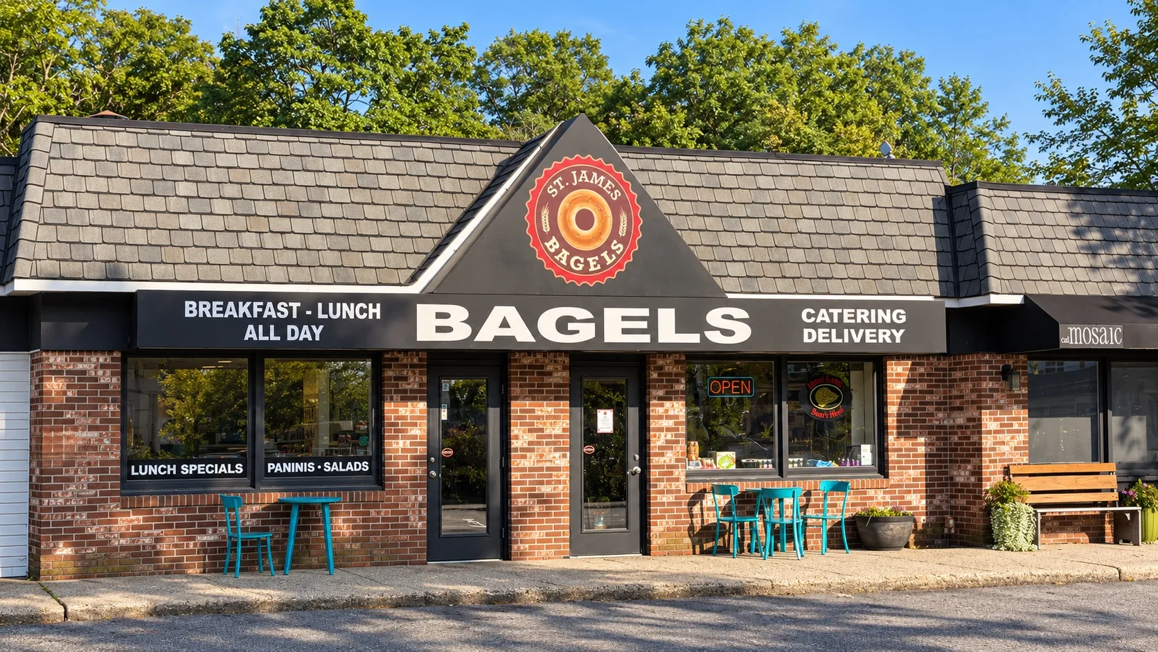 St. James Bagels storefront, brick building with black awning reading Bagels, Catering, Delivery
